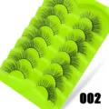 Detaillierte Nahaufnahme von sieben Paaren fluffiger künstlicher Wimpern auf grüner Platte. - 7 Paar Grüne Verlaufs-Serie (002)