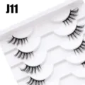 Nahaufnahme der mehrlagigen, geschwungenen künstlichen Wimpern auf einem weißen Tablett. - 10 Paare Weiß Stufe Halbes Auge J11