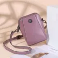Purple leather crossbody phone bag detail showing fine stitching and floral metal button clasp. - Taro Purple