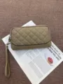 Close-up detail of the quilted genuine leather long wallet with zipper and wrist strap. - Gray