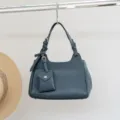 Elegante bolso de hombro de cuero genuino para mujer, bolso chic con pequeño colgante. - Verde azulado