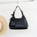 Black genuine tumbled cowhide leather crossbody shoulder handbag with small pouch pendant detail. - Black