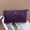 Purple genuine top layer cowhide leather clutch purse with metal clover logo and wrist strap detail. - Purple