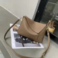 Vista detallada del bolso bandolera de cuero genuino taupe con solapa geométrica. - Marrón Castaña