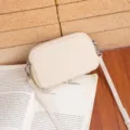 Minimalist beige genuine leather crossbody camera bag with metal zipper and fine strap. - Off White