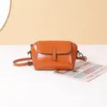 Vista detallada del bolso cruzado retro de cuero caramelo con solapa y cierre metálico. - Caramelo
