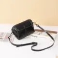 Classic black leather crossbody bag with flap and slim strap for women detail view. - Black
