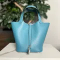 Vista dettagliata della borsa in pelle blu con cuciture e serratura in metallo argentato. - Blu denim con fibbia argentata