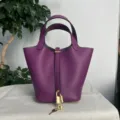 Vista dettagliata della borsa a secchiello in pelle viola con lucchetto in metallo. - Viola anemone con fibbia dorata