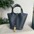 Borsa a secchiello in pelle blu scuro con ferramenta dorata e lucchetto, elegante borsa chic. - Blu notte con fibbia dorata