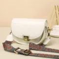 Vintage leather saddle bag for women, stylish wide strap crossbody bag with retro hardware. - White