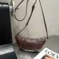 Dark brown leather croissant shoulder bag with adjustable strap and zip closure stylish. - Coffee
