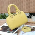 Vue détaillée du sac Boston en cuir jaune véritable, avec poignées et bandoulière. - Jaune