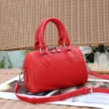Red genuine leather Boston shoulder bag detail view with metallic zippers and top handles. - Red