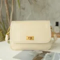 Close-up detail of vintage leather crossbody bag, minimalist flap design with metal turn-lock. - Off White
