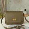Detalle de bolso bandolera retro de cuero oliva, cierre metálico vintage y correa ajustable. - Verde yucca