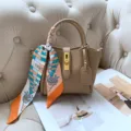 Detailed shot of a beige leather bucket bag with a chic hot air balloon patterned scarf. - Milk Tea [Ready to Ship]