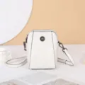 Vue détaillée du sac bandoulière en cuir blanc avec ornement de fleur en métal élégant. - Blanc