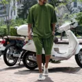 Outdoor detail shot of men's casual green short sleeve t-shirt and shorts set worn by model. - Army Green