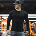 Detailed view of men's slim fit solid color long sleeve Henley t-shirt for sports fitness. - Henley Black