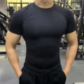 Detail view of mens black short sleeve compression fitness shirt, tight athletic gym training top. - S / Tops / Black