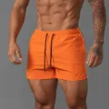 Men orange athletic shorts featuring black drawstrings and white side stripes for sports. - M / Orange Plain