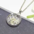 Close-up of white dried flower preserved in clear glass ball pendant necklace detail - White Snow Flower Round Silver Necklace