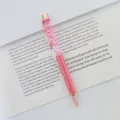 Close-up of elegant rose gold floating ballpoint pen with pink dried flowers and oil - 1.0mm Bullet Tip / Rose Red