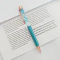 Elegant teal metal ballpoint pen featuring blue dried flowers in clear floating oil - 1.0mm Bullet Tip / Peacock Blue