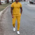 Detailaufnahme vom gelben Herren Poloshirt und Freizeithose Set draussen auf der Strasse. - S / Set / Gelb