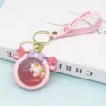 Cute pink liquid keychain with cute cartoon character pendant, quicksand strap and metal ring. - With Small Doll / Pink