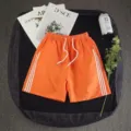 Orange casual sports shorts for men and women, summer loose five-point beach shorts with white stripes. - S / Orange