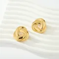 Primer plano de pendientes de nudo dorados con textura plisada en expositor blanco - Estilo plisado con nudo en espiral (Fig 6)