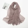 Close-up detail of the crumpled cotton-linen scarf featuring delicate fringed edges and soft texture. - Khaki Pink