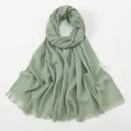 Detailed view of sage green slub cotton scarf texture with fringe tassel edge detail. - Grass Green