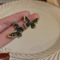 Macro detail of elegant black crystal butterfly stud earrings in luxury gold-tone plating. - Full Rhinestone Butterfly Stud Earrings (N3700) / Gold-Edged Butterfly