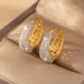 Elegant U-shaped hoop earrings with gold plating and sparkling cubic zirconia stones. - Gold