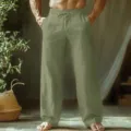 Detail view of men's casual linen trousers featuring drawstring waist and relaxed fit. - Army Green