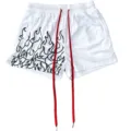 Close-up of white mesh athletic shorts featuring black flame print and long red drawstrings. - S / White