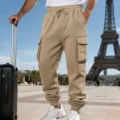 Detailed view of men's khaki cargo sweatpants with drawstring waist and side pockets in urban setting. - S / Khaki