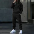 Detailed shot of black men's lace-up hoodie and multi-pocket cargo pants set in urban style. - S / Black