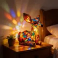 Stained glass style deer LED night light casting colorful light in a cozy bedroom setting - Deer Night Light (Button Battery)