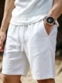 Detail shot of men's white linen shorts featuring elastic drawstring waist and breathable fabric. - S / White