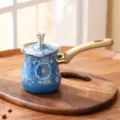 Cafetière turque émaillée bleue avec motif floral coloré et poignée en bois pratique. - Motif 5
