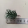 Artificial green pine needle sprig for Christmas tree decor, shown with measuring ruler - Length 10cm Diameter 6cm