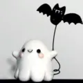 Cute white resin ghost figurine holding a black bat balloon for Halloween decor - Bat Little Ghost