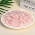 Natural polished pink rose quartz crystal chips displayed on a white ceramic plate - Light Pink Quartz / 9-12mm (100g)