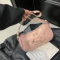 Bolso de hombro de moto de cuero rosa con hebillas y tachuelas metálicas, estilo chic. - Rosa