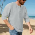 Detaillierte Ansicht des grauen Langarm-Henley-Shirts für Herren am Strand Hintergrund. - S / Hellgrau