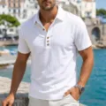 Nahaufnahme eines atmungsaktiven weißen Herren-Poloshirts aus Leinen mit kurzen Ärmeln. - S / Oberteile / Weiß
